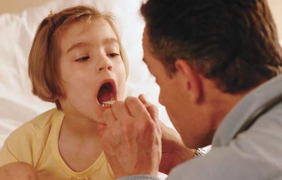 врач смотрит горло у ребенка