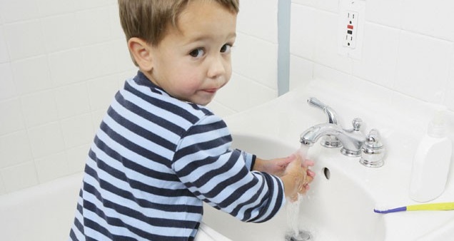 Мальчик моет руки, чтобы не заболеть инфекцией