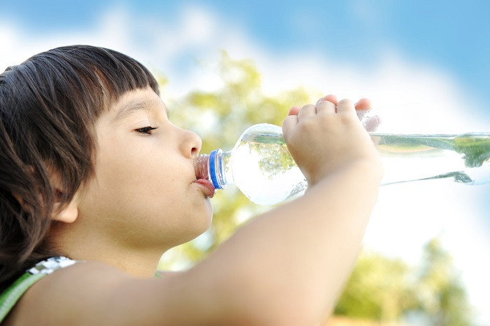 Ребенок пьет воду из бутылки
